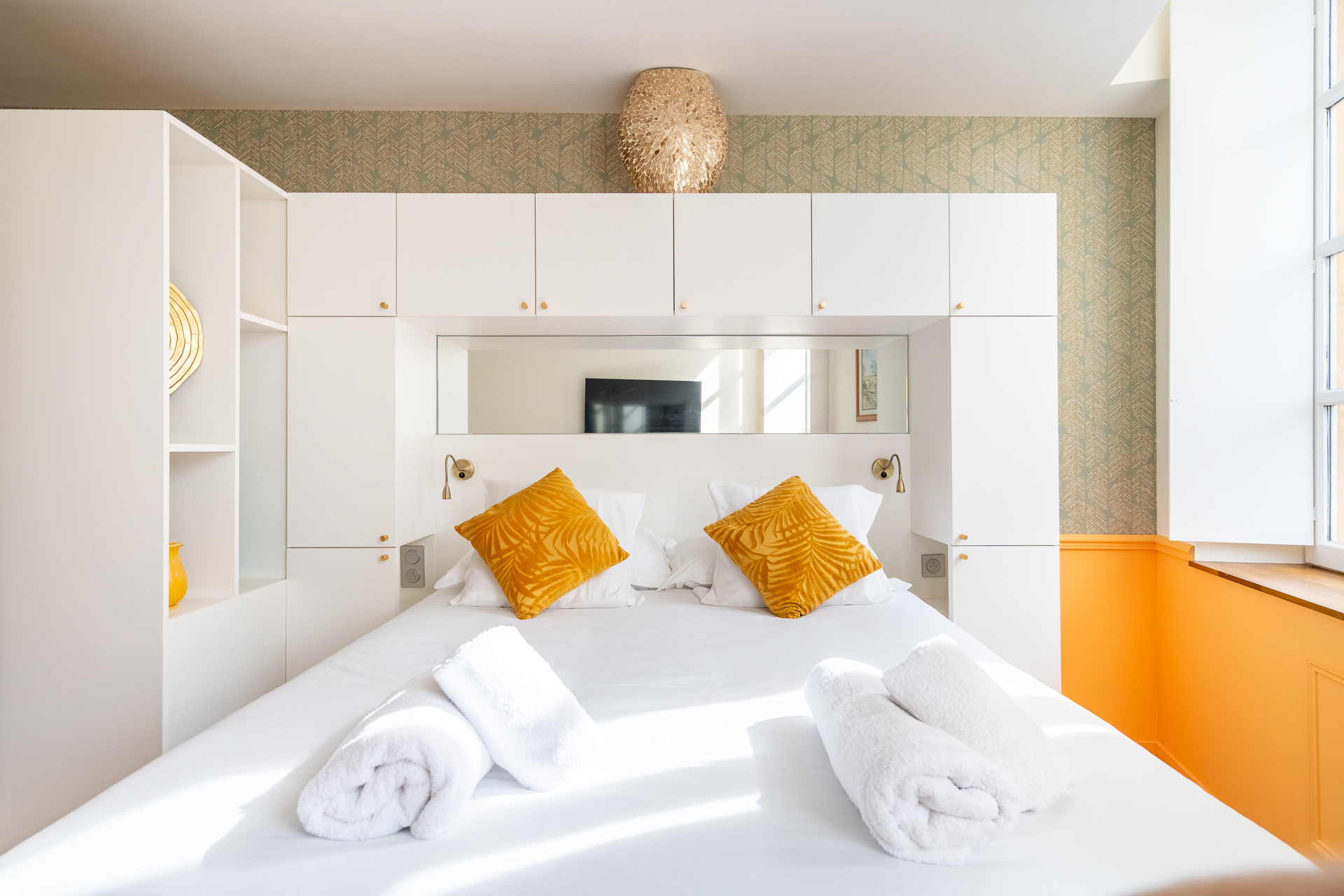 Chambre Deluxe : lit face aux boiseries blanches et miroir