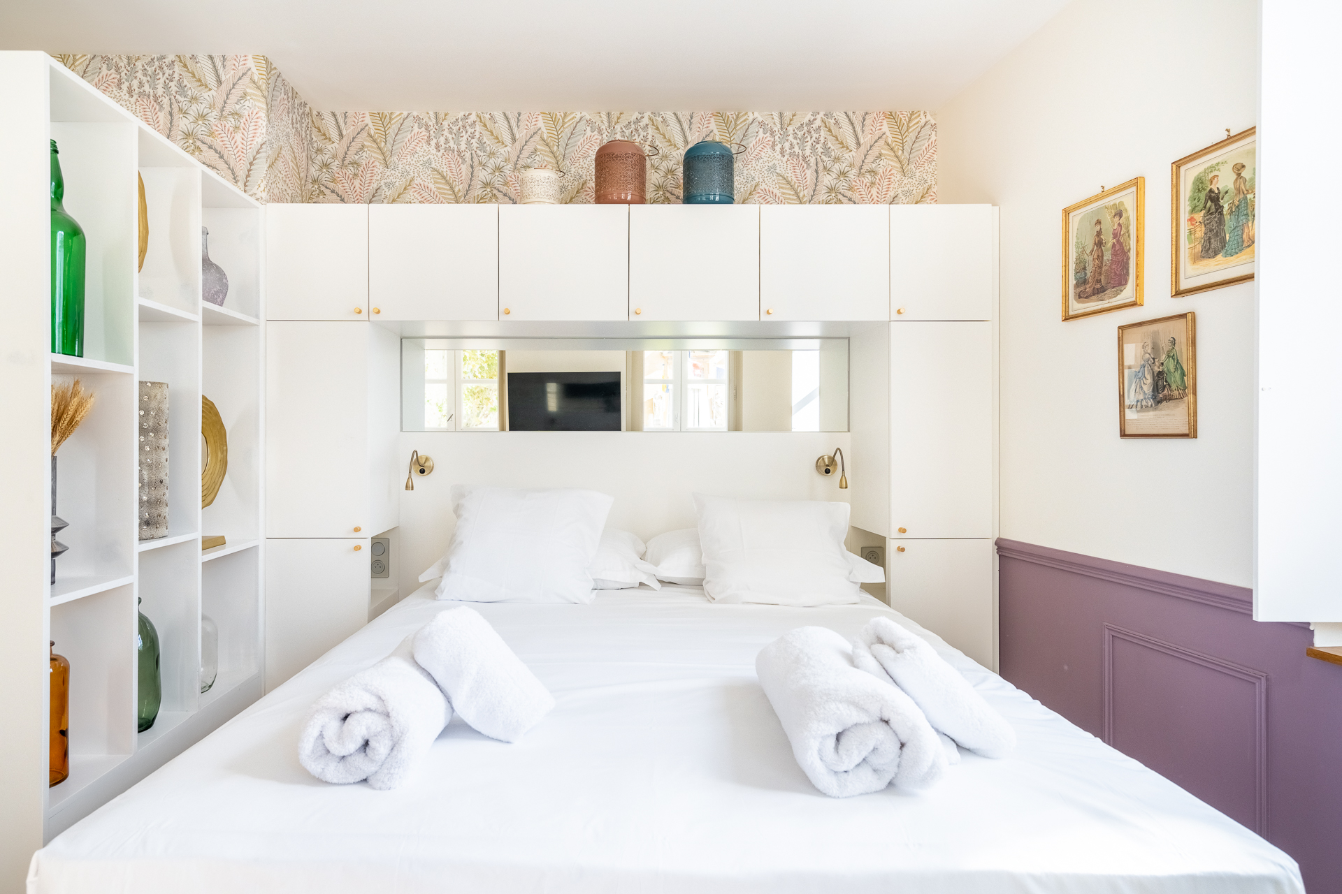 Chambre Deluxe : lit face aux boiseries blanches et au miroir