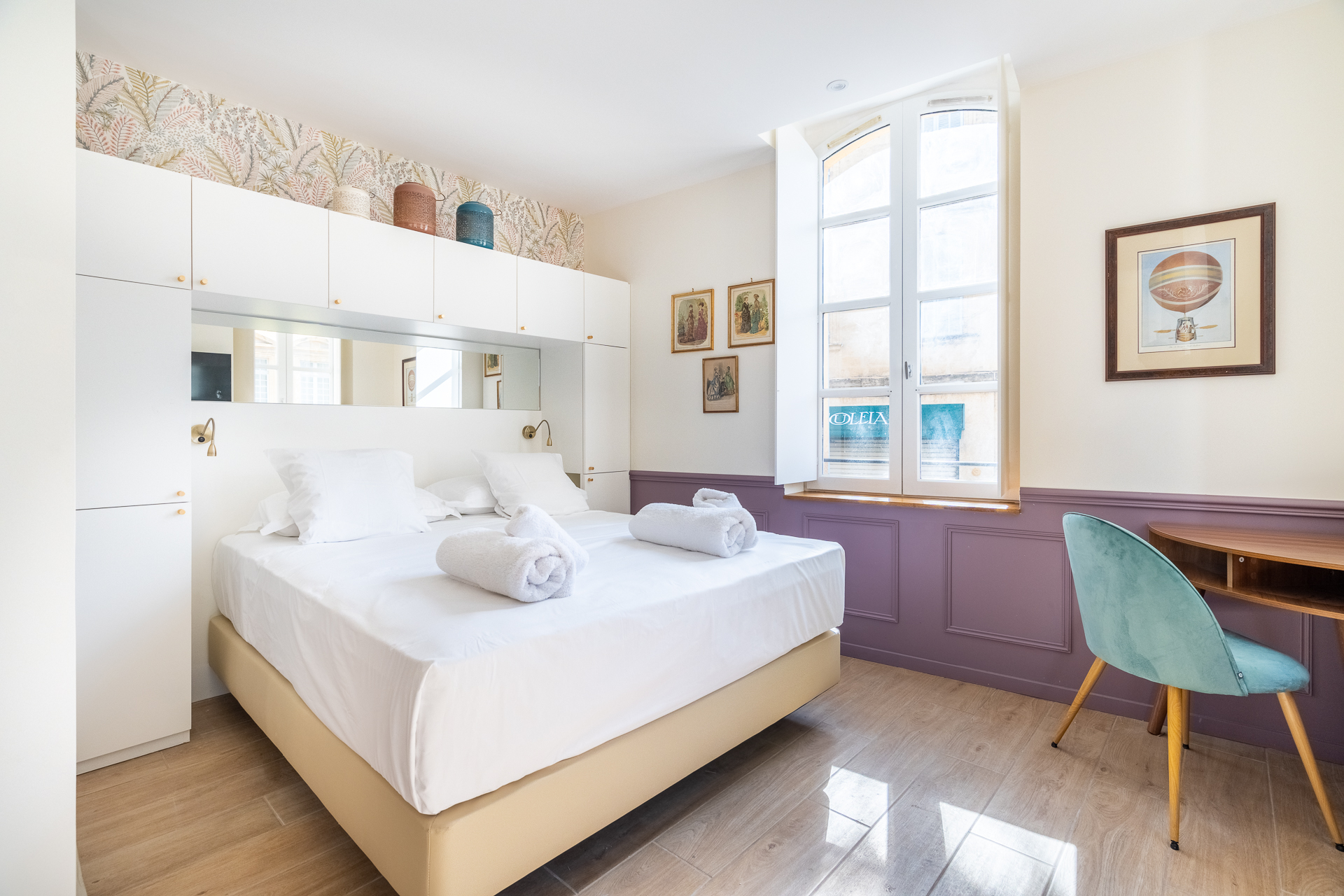 Chambre Deluxe : lit et bureau devant une fenêtre cintrée